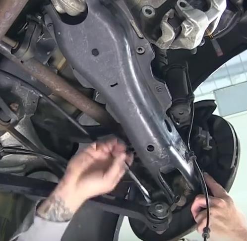 File:W220 Undoing spring control arm to wheel carrier bolted connection.jpg